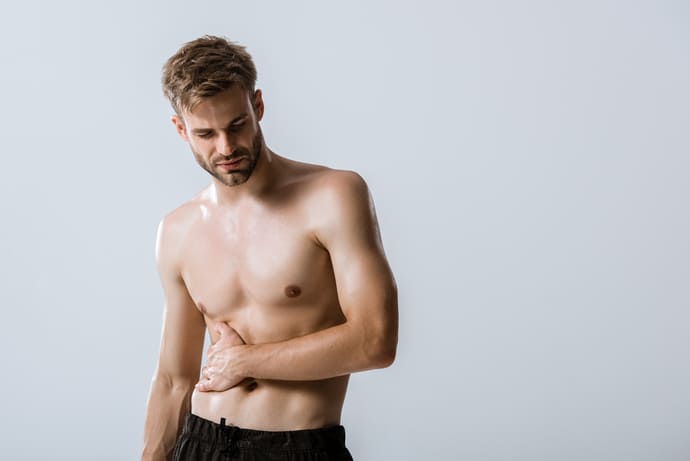 Mężczyznę boli brzuch, bo zjadł za dużo kapusty kiszonej.