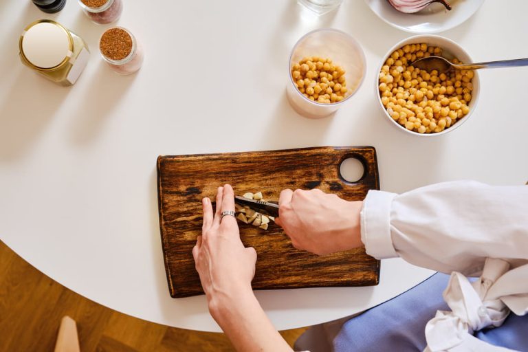11 osoba szczupla przy stole a na desce ciecierzyca soczewica makaron jablka pomidory Cukry złożone w cateringu dietetycznym FitApetit – dlaczego są ważne dla zdrowia?