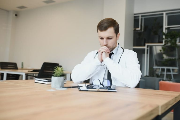 lekarz siedzacy za biurkiem Czy makrela wędzona pasuje do cateringu dietetycznego?