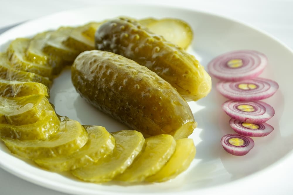 Ogórki kiszone w cateringu - kalorie, wartości odżywcze i wpływ na organizm 4 Ogórki kiszone na talerzu, które pomagają uzupełnić niedobory witamin i minerałów w diecie, wspierając zdrowie.
