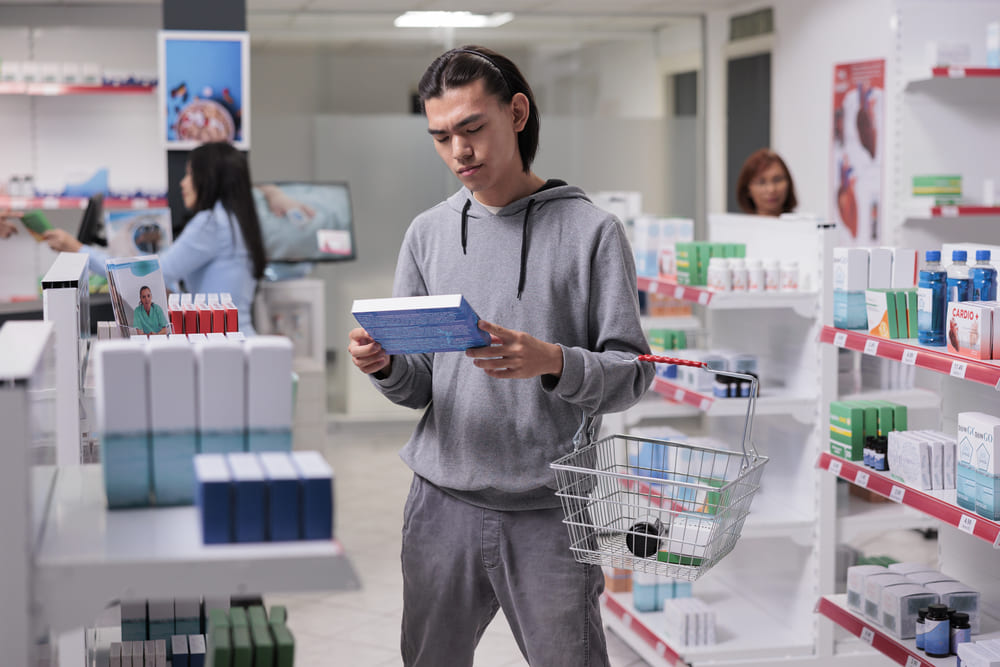 Kobieta w aptece rozmawiająca z farmaceutą na temat wypłukiwania magnezu przez kawę. 